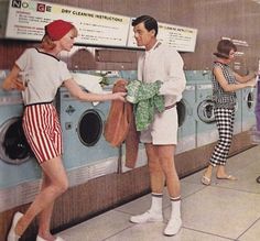 two women and a man standing in front of a washing machine