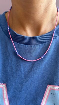 a person wearing a blue shirt and pink necklace