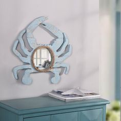 a blue dresser sitting next to a mirror on top of a wall