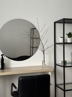 a mirror sitting on top of a wooden table next to a shelf filled with plants