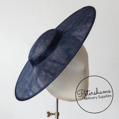 This french navy cartwheel hat base is a classic shape that has sprung into popularity in the past year. Made from 2 layers of stiffened sinamay, these cartwheels are ready to trim and are fitted with a petersham ribbon on the inside crown edge. Simply add a comb or headband to secure to the head.Hat base measures:Width: 35.5cm (14 inches)Crown Width: 13.5cm (5.3 inches)Crown Height: Approximately 3.5cm (1.7 inches)For even more millinery supplies you can find us here:www.etsy.com/shop/Petersham Adjustable Flat Brim Costume Hats For Church, Adjustable Flat Brim Top Hat For Church, Spring Navy Adjustable Hats, Fitted Hat With Round Crown For Kentucky Derby, Classic Fitted Fascinator With Wide Brim, Adjustable Hat With Round Crown For Summer, Classic Wide Brim Adjustable Fascinator, Classic Adjustable Wide Brim Fascinator, Classic Wide Brim Fitted Fascinator