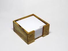 a wooden box with several cards in it on a white surface and the lid is open