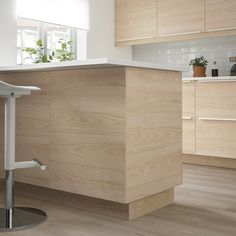 a kitchen with wooden cabinets and white counter tops, an island in front of the sink