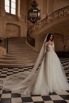 a woman in a wedding dress standing on a checkered floor with her veil pulled back