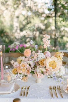 the table is set with flowers and candles