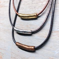 "Simple and classic leather cord and metal tube necklace. I use a 1\" long metal tube ring paired with genuine 2mm leather cord. For those looking for a more delicate or understated look this is the perfect necklace! Handmade statement necklace made with 2mm premium leather cord featuring a 1\" (26mm) organic metal tube in either antique gold, antique silver or antique copper. Each necklace features a matching lobster clasp. Choose your necklace length. Made from premium leather using the most s Leather And Metal Jewelry, Minimalist Necklace With Adjustable Cord For Everyday Use, Minimalist Everyday Necklace With Adjustable Cord, Minimalist Everyday Leather Necklace, Boho Leather Necklace, Pmc Jewelry, Leather Necklaces, Handmade Statement Necklace, Tube Necklace