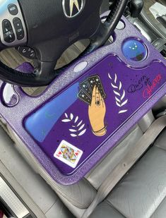 the interior of a car with a steering wheel and purple carpeted floor mat on it