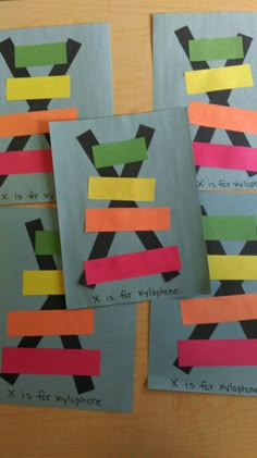 four pieces of paper taped together to make an x and y symbol with colored strips