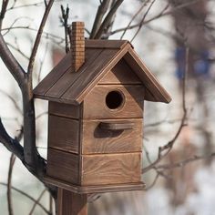 a wooden bird house sitting on top of a tree