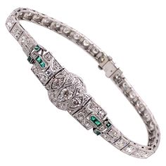 Vintage 1930's Art Deco Platinum Diamond and Emerald Bracelet - The bracelet contains 33 European cut diamonds that weigh approximately 2.50ct, and an additional 32 single cut diamonds that weigh approximately .50ct. The diamond quality is G - I color and VS - SI clarity. There are 8 French cut emeralds that weigh approximately .25ct. The bracelet measures 7.25 inches long, .40 inches wide in the middle and .16 inches wide along the rest of the bracelet. The clasp is a plunger style with a safet Vintage White Gold Hand-set Bracelets, Vintage Platinum Tennis Bracelet For Anniversary, Vintage Diamond Bracelet With Hand-set Diamonds, Vintage Hand Set Diamond Bracelet, Vintage Round Brilliant Cut Diamond Bracelet, Vintage Formal Tennis Bracelet With Single Cut Diamonds, Vintage Round Diamond Bracelet Hallmarked, Art Deco White Gold Tennis Bracelet With 17 Jewels, Vintage Round Hallmarked Diamond Bracelet