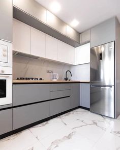 a modern kitchen with marble flooring and stainless steel appliances