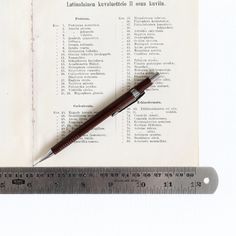 a pen sitting on top of a piece of paper next to a ruler