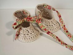 two crocheted baby shoes with a ribbon tied around them