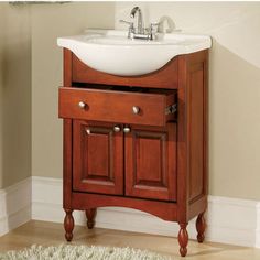 a bathroom vanity with a white sink and wooden cabinet