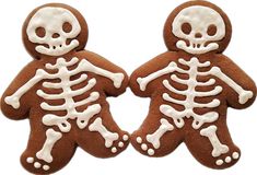 two decorated cookies with white frosting on top of each cookie, one has a skeleton and the other is a ginger