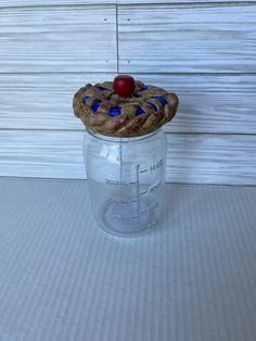 a cookie in a jar with a cherry on top