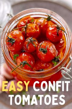 a glass jar filled with tomatoes on top of a table