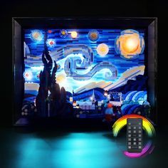 a remote control sitting on top of a table in front of a television screen with the image of a starry night