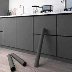 a kitchen with green cabinets and pipes in the floor, next to a counter top