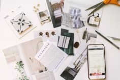 the table is cluttered with various items such as paper, scissors and cell phone