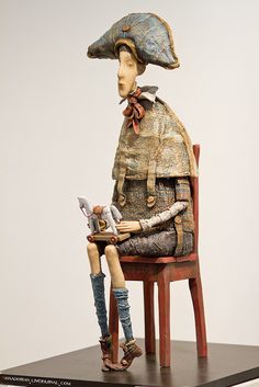 a doll sitting on top of a wooden chair