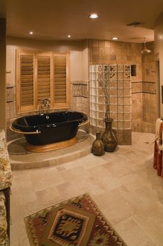 a bath room with a large tub next to a walk in shower and a sink