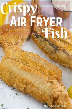 crispy air fryer fish on a plate with lemon wedges