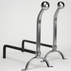 two metal stands with balls on them against a white background