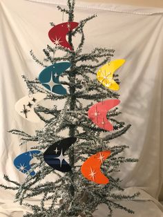 a small christmas tree with many different colored ornaments hanging from it's top and bottom