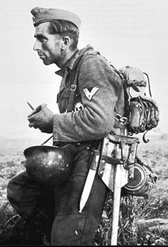 an old black and white photo of a man in uniform with a backpack on his back