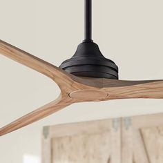 a ceiling fan with wooden blades in a room