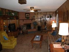 a living room filled with furniture and a flat screen tv sitting on top of a wooden wall