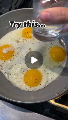 someone is frying eggs in a pan on the stove with water and seasonings