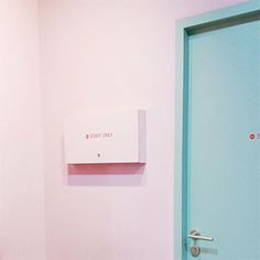 a bathroom with pink walls and a blue door in the corner that leads to another room