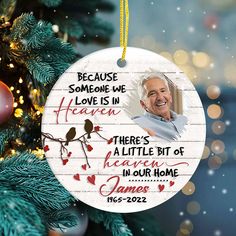 a christmas ornament hanging from a tree with a photo of an older man