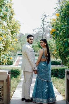 a man and woman standing next to each other in front of some lemon trees on a sunny day