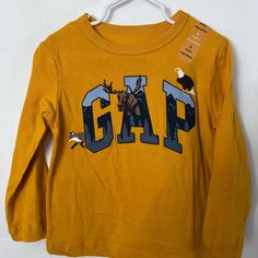 Gold Color T Shirt With Navy/Gray/Black/Brown Size 3 Nwt Gap Letter Print Tops For Winter, Gap Tops With Letter Print For Winter, Gap Winter Tops With Letter Print, Gap Long Sleeve Top With Letter Print, Gap Long Sleeve Winter Tops, Gap Cotton Crew Neck T-shirt, Gap Graphic Print T-shirt, Trendy Cotton Gap T-shirt, Girls Disney Shirts