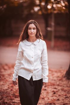 This womens peter pan collar hemp blouse is a classic and timeless piece that will be perfect for any formal or casual event. Made from 100% european hemp fabric, this shirt features a peter pan collar and long sleeve style. Featuring natural shell buttons Hemp is a natural, breathable fabric, suitable in any season because it regulates body temperature, is soft and pleasant to wear on the skin. Composition: 100% European Hemp, the fabric is Oeko-Tex 100 class I certified.  ABOUT * Handmade from White Spread Collar Blouse For Fall, Classic Linen Blouse With Buttons, Elegant Linen Blouse With Spread Collar, Fall Blouse With Fold Down Collar And Buttons, Linen Blouse With Collar For Workwear, Linen Workwear Blouse With Collar, Classic Blouse With Peter Pan Collar For Fall, Classic Shirt With Peter Pan Collar And Button Closure, Collared Linen Blouse For Fall