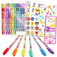 various pens and stickers are displayed in front of a book with disney characters on it