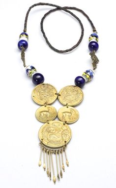 Vintage Peruvian Coin Tribal Beaded Necklace-Statement necklace with 5 jump ring connected Peruvian coins-Hanging from the bottom large coin are brass pins with flattened, pointed ends-Painted scene ceramic beads and dark blue glass beads are connected with 2 brass metal God figural beads-A simple braided leather strand is connected to the beading a coin section-No clasp, simply pull over the head-Length of beaded section approx 9.5"-Drop is about 4.5" including the length of the pins-Total wear Bohemian Brass Coin Necklace, Adjustable Brass Coin Necklace, Festival Coin Pendant Necklace In Medallion Shape, Traditional Brass Coin Necklace, Handmade Amulet Coin Necklace, Traditional Handmade Medallion Coin Necklace, Bohemian Metal Coin Necklace, Bohemian Brass Medallion Coin Necklace, Handmade Antique Coin Necklace For Festival