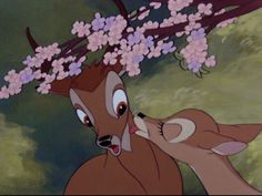 an animated image of two deers with flowers in their hair and one is kissing the other