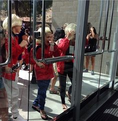 a group of people standing in front of a glass door with their arms around each other