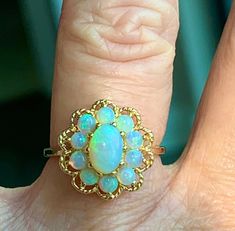 "Opal ring, vintage Australian opal engagement ring in 14k yellow gold. Beautiful center opal stone with wonderful blue and green color hues. Center stone measures 7mm x 5mm (about .55 carat). Ten accompanying stones measure ~2.8mm each and are superbly matched with the main opal, estimated .08 carat each. Total opal carat weight for the ring is estimated 1.19 carats. Excellent condition! Ring weighs 3.4 grams. Size 6 and can be sized +- 3.5 sizes by adding sizing to your order for 45- here: htt Classic Luxury Yellow Gold Opal Ring, Luxury Cabochon Opal Ring For Engagement, Victorian Style Opal Round Rings, Victorian Multi-stone Opal Ring As Gift, Victorian Multi-stone Opal Ring For Gift, Victorian Multi-stone Opal Ring, Victorian 14k Gold Opal Ring Gift, Opal Cabochon Ring In 14k Gold For Anniversary, 14k Gold Cabochon Opal Anniversary Ring