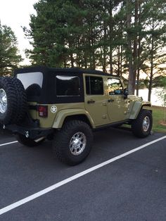 a green jeep parked in a parking lot