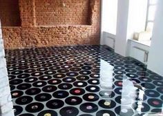 an empty room with black and white circles on the floor in front of a brick wall