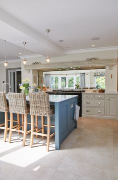 a large kitchen with an island in the middle and four chairs around it on the side