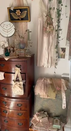 an old dresser is next to a bed and wall hangings with pictures on it