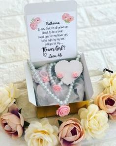 a box that has some flowers and pearls in it with a card on the inside