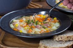 a bowl filled with soup next to two slices of bread