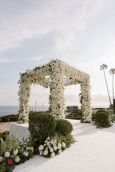 an outdoor ceremony with white flowers and greenery